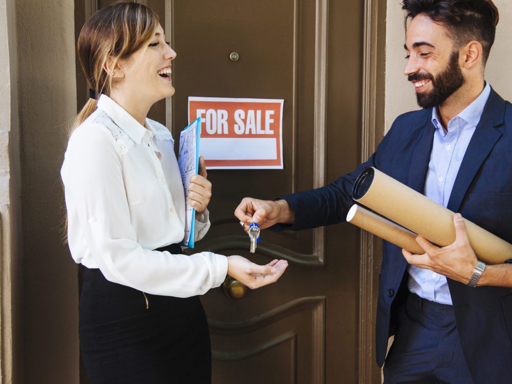 real-estate-agent-giving-key-woman